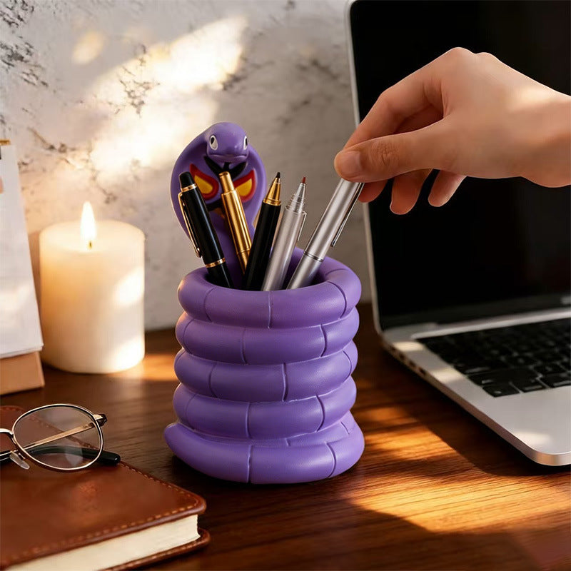 Arbok Figure Pen Holder beside laptop