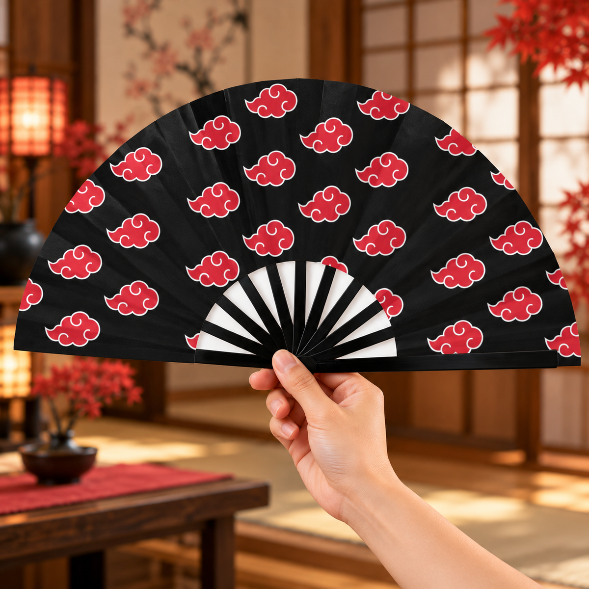 Akatsuki clouds folding fan held open in a warm Japanese-inspired interior