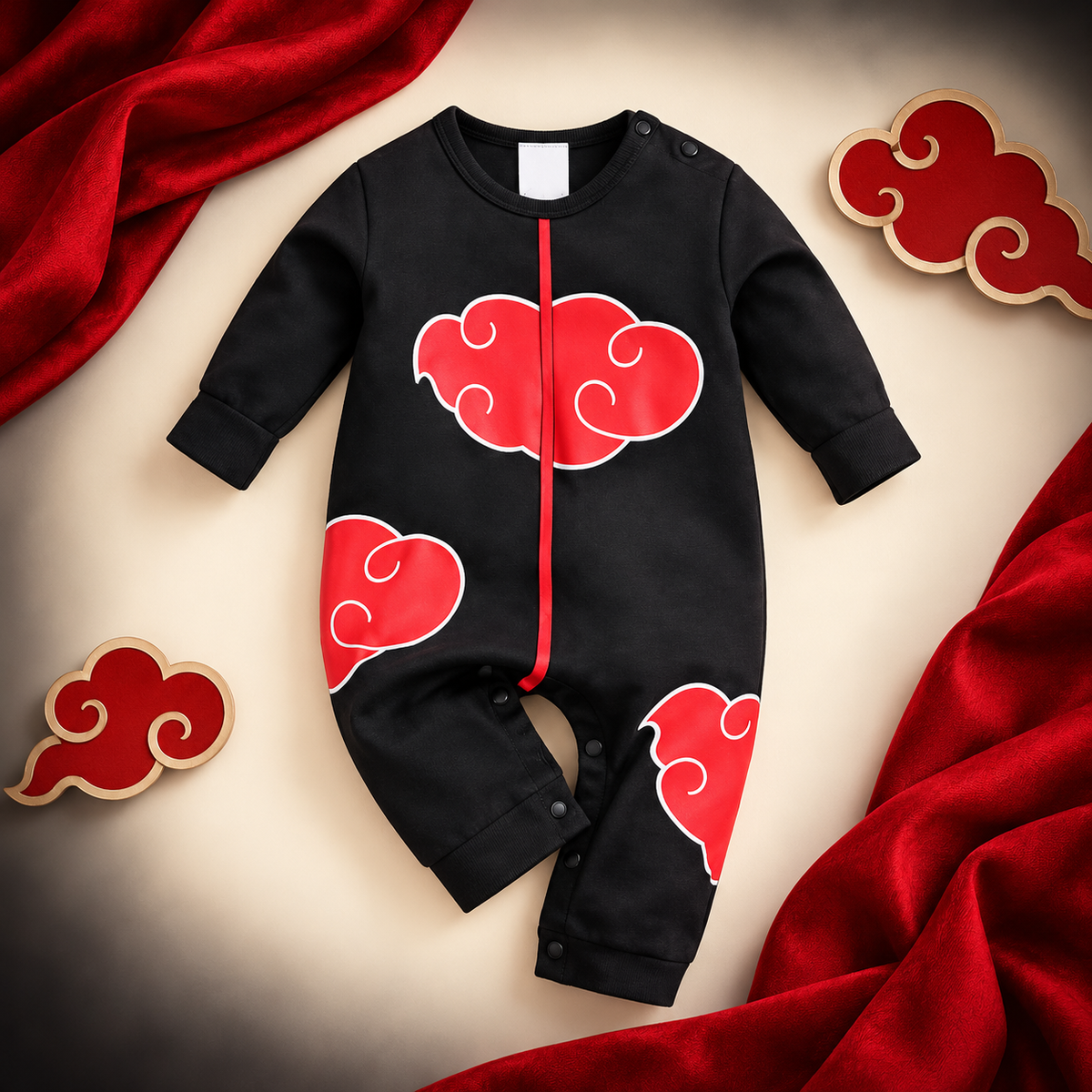 Black Akatsuki-inspired baby onesie with red cloud details on a cream and crimson studio backdrop