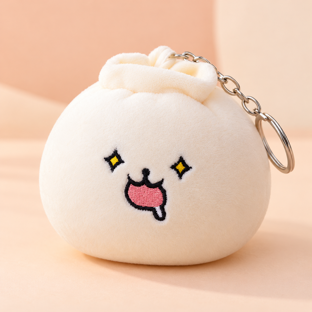 Three-quarter view of the dumpling plush keychain showing its silver chain