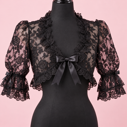 Close-up of floral lace and satin bow on the black bolero