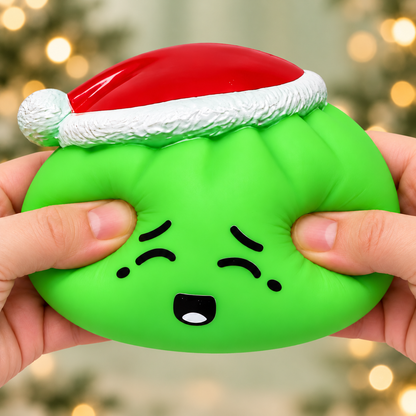 Green Elf Dumpling Squishy being squeezed with sage holiday background