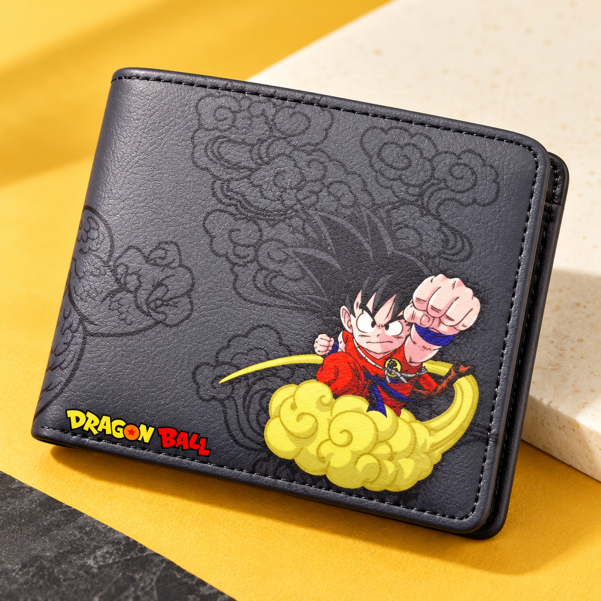 Angled Goku Nimbus wallet on a golden yellow and ivory display surface