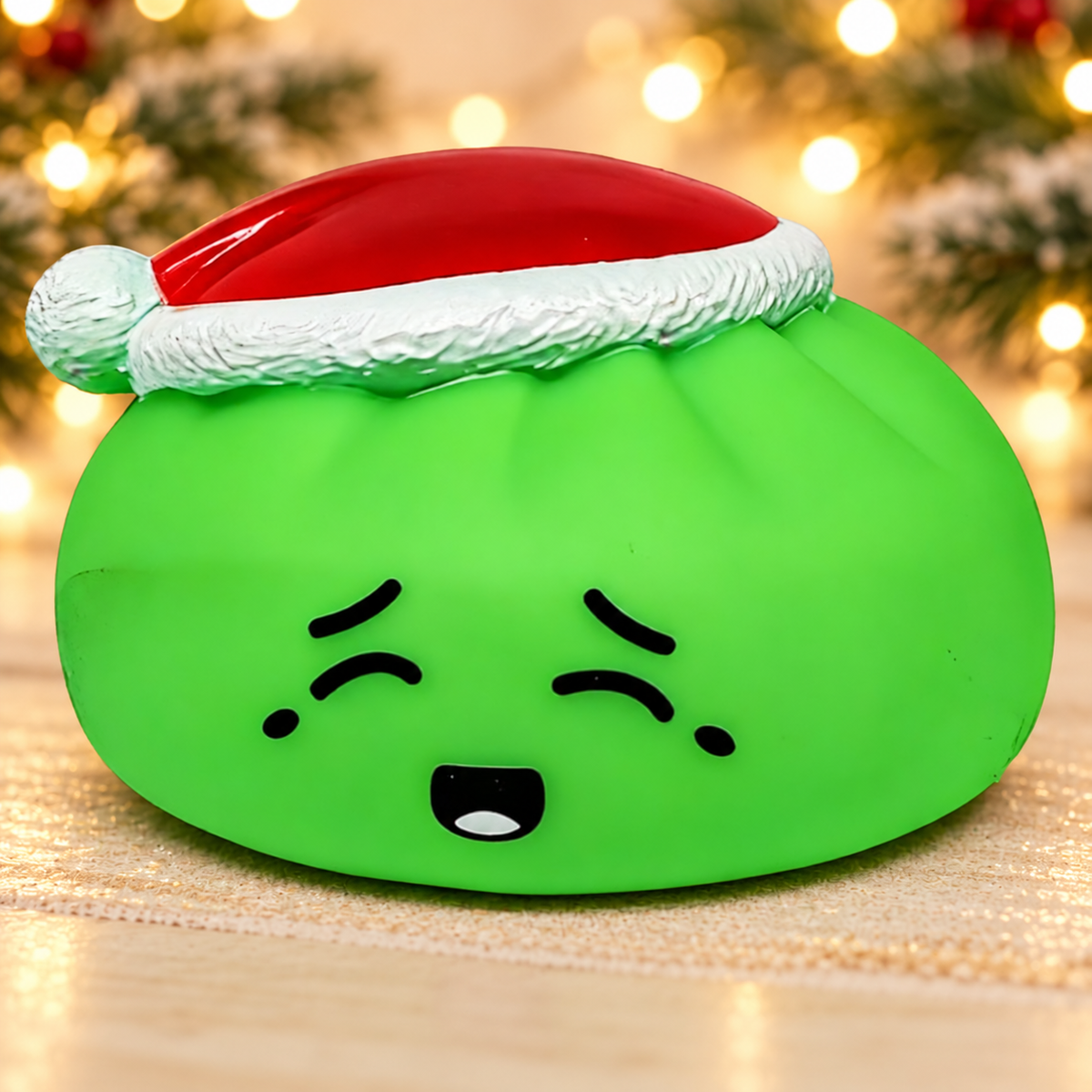 Green Elf Dumpling Squishy with warm holiday lights background