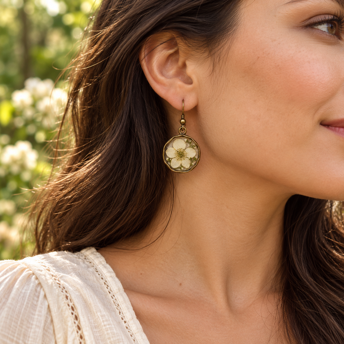 Floral Mori Kei earring worn with dark hair and cream blouse