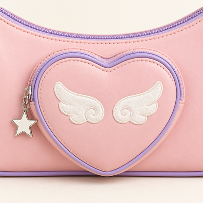 Close-up of the heart pocket and angel wing charm on the shoulder bag