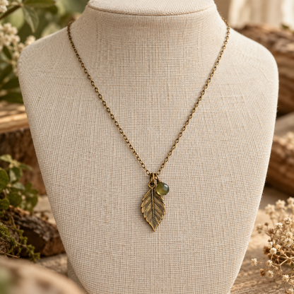 Antique brass leaf pendant necklace on ivory linen