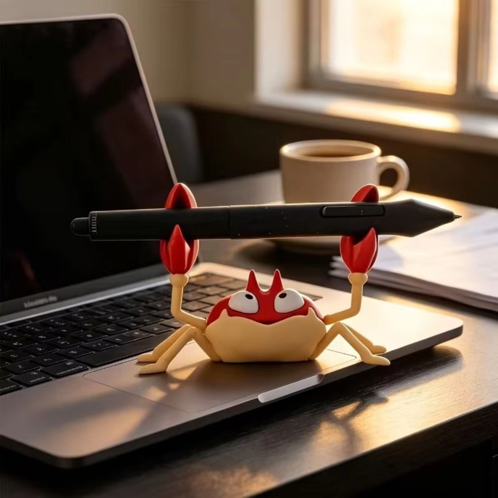 Krabby Figure Pen Holder holding a black stylus beside a laptop