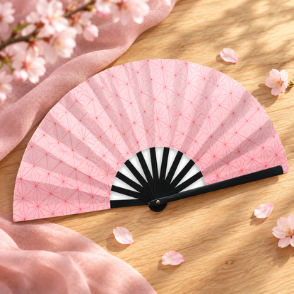 Nezuko-style folding fan on wood with soft pink blossoms