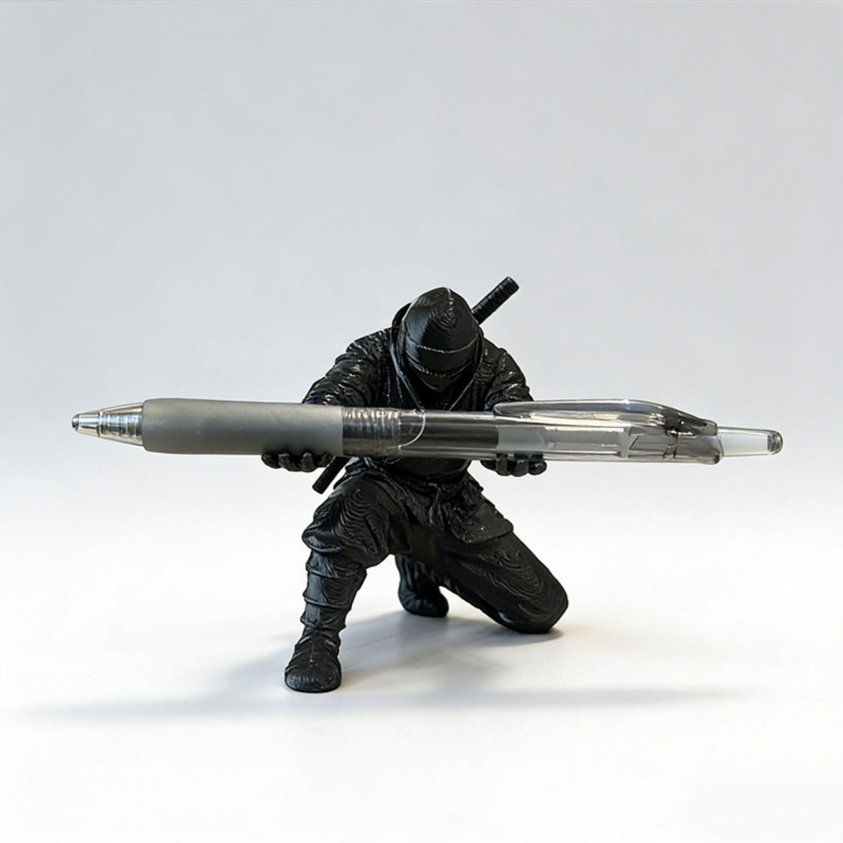 Dramatic black-and-white scene of the ninja figure holding a pen