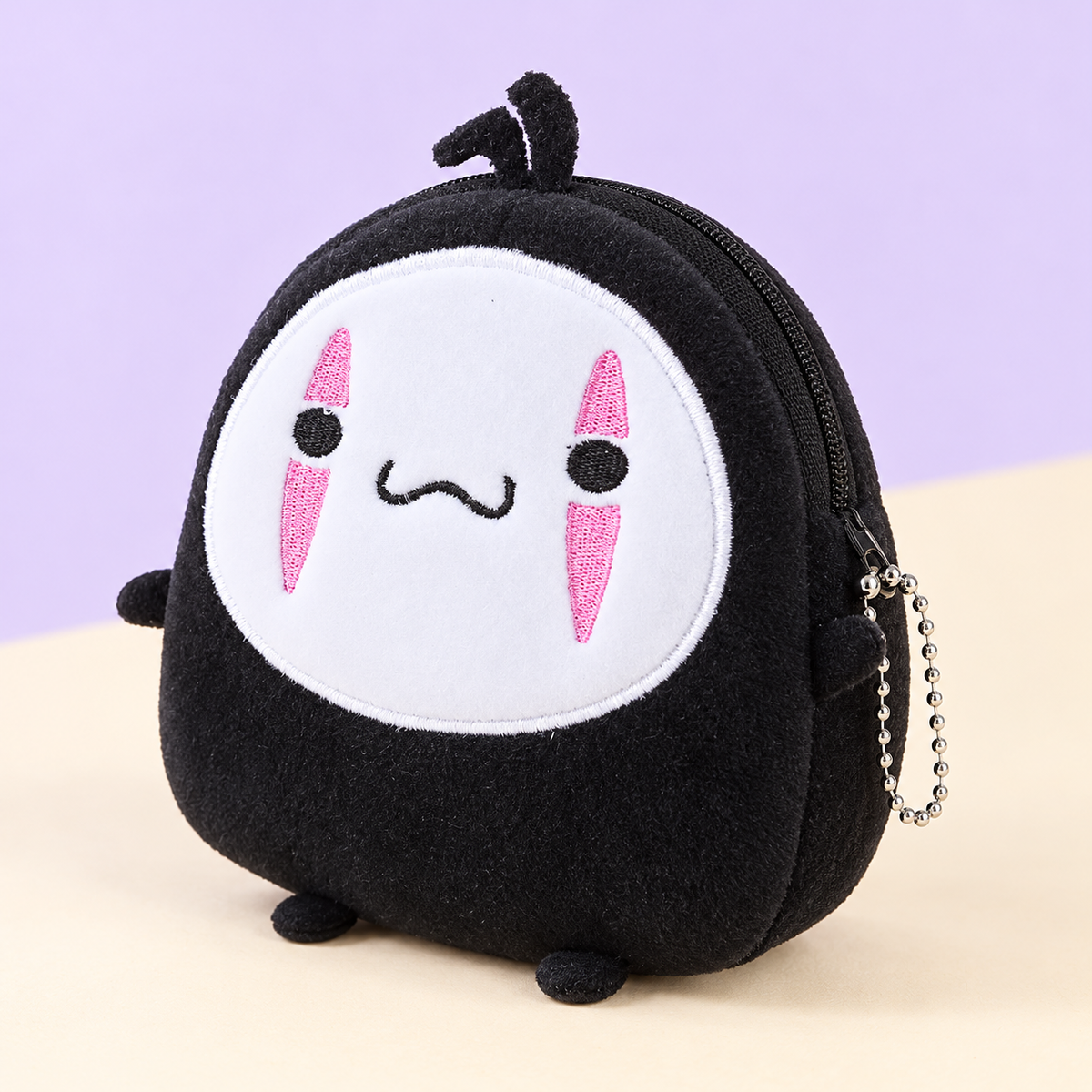 Angled No Face plush coin wallet showing its side zipper and silver ball chain