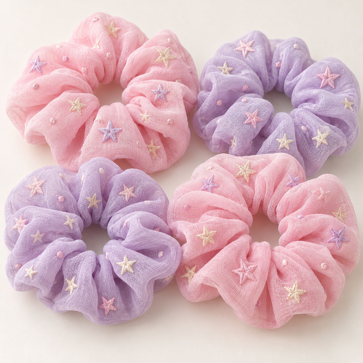 Close-up of pastel pink and lavender star embroidered scrunchies