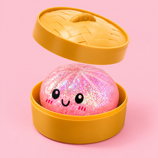 Pink Glitter Dumpling Squishy in its case on a plain blush pink pastel background