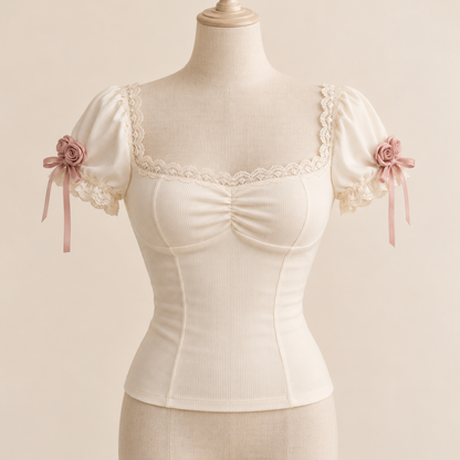Ivory fitted top with dusty rose rosettes and lace neckline