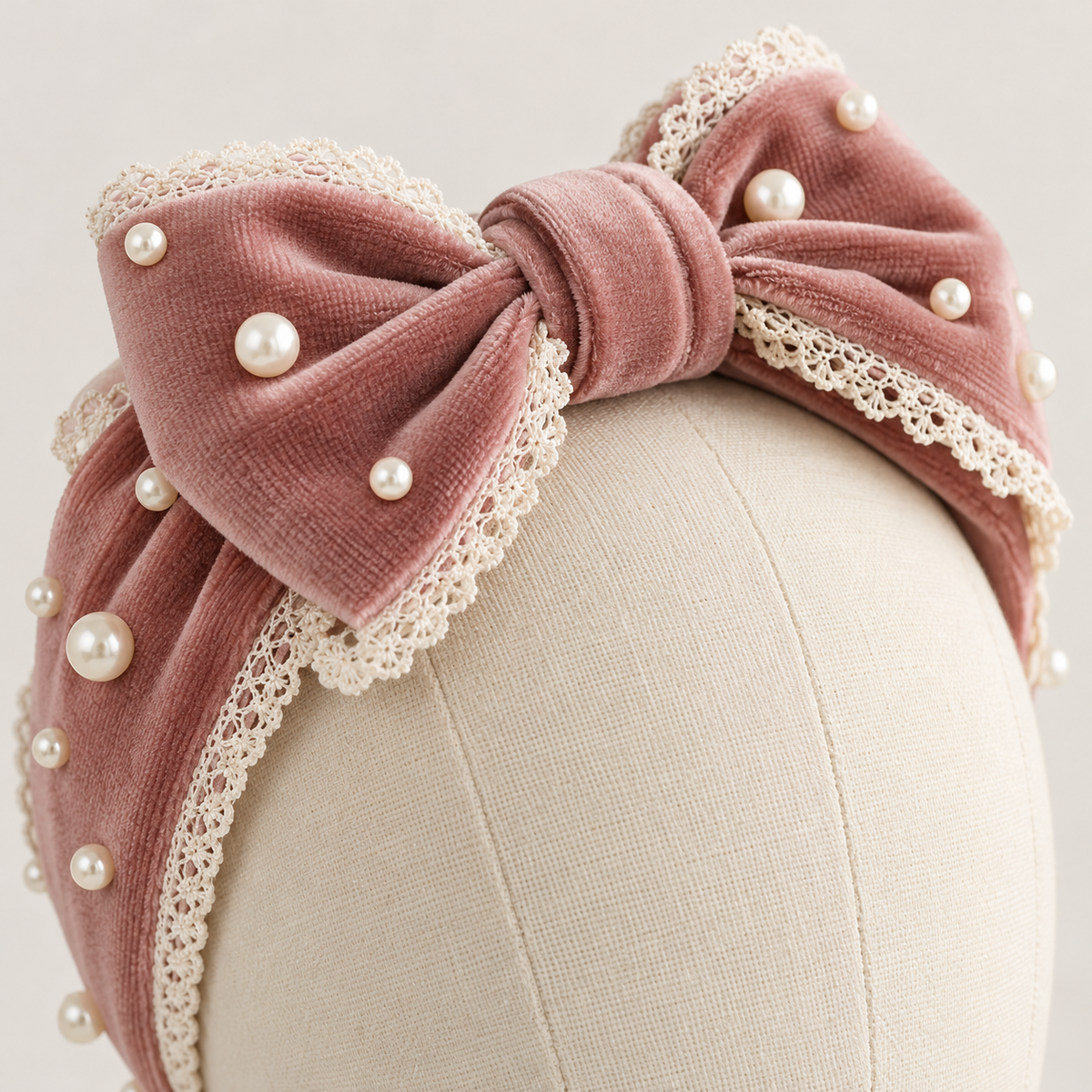Close-up of dusty rose velvet headband bow and lace