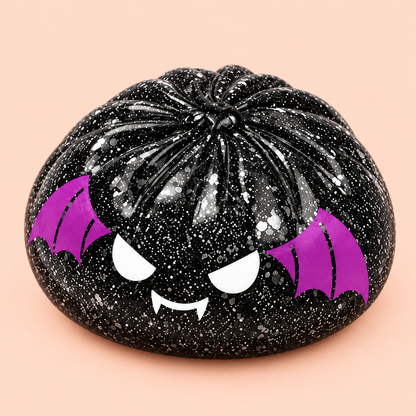Close-up of black glitter Spooky Bat Squishy with purple wings and fangs